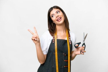 Seamstress woman over isolated white background smiling and showing victory sign