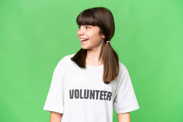 Little Volunteer Girl Isolated Background Looking Side Smiling — Foto de Stock
