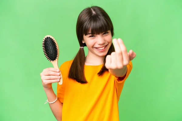 Little caucasian girl with hair comb over isolated background inviting to come with hand. Happy that you came