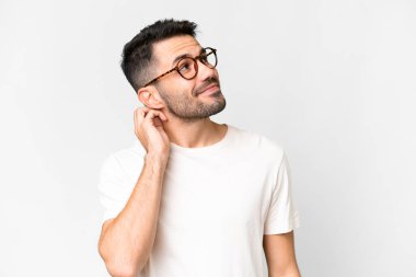 Soyutlanmış beyaz bir arka planda yaşayan yakışıklı beyaz bir adam bir fikir düşünüyor.