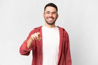 İzole edilmiş beyaz arka planı olan yakışıklı beyaz bir adam şaşırmış ve ön tarafı işaret ediyor.