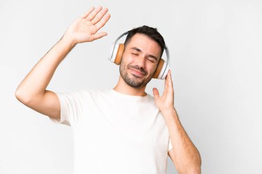 Beyaz arka planda yaşayan yakışıklı beyaz adam müzik ve dans dinliyor.