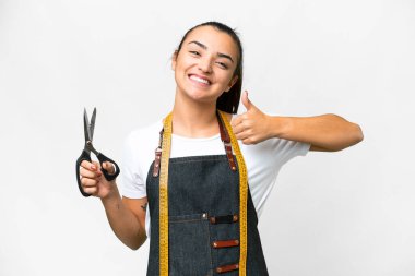 Terzi kadın, izole edilmiş beyaz arka planda baş parmak hareketi yapıyor.