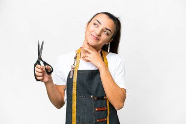 Terzi kadın, izole beyaz arka planda gülümserken yukarı bakıyor.