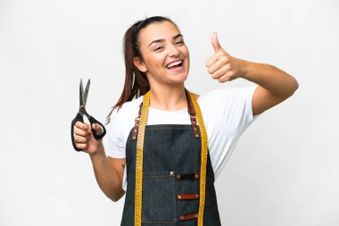 Terzi kadın izole edilmiş beyaz arka planda. Başparmakları havada. Çünkü iyi bir şey oldu.