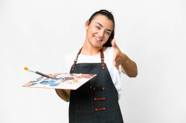 İzole edilmiş beyaz arka planda palet tutan genç bir sanatçı iyi bir anlaşma için el sıkışıyor.