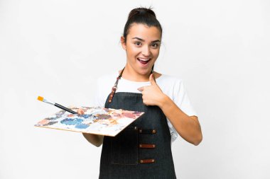 İzole edilmiş beyaz arka plan üzerinde palet tutan genç bir sanatçı.