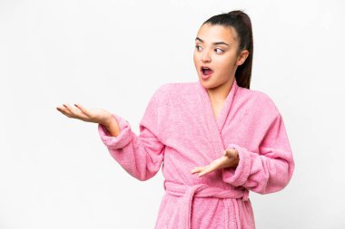 İzole edilmiş beyaz bir arka planı olan bornozlu genç bir kadın.