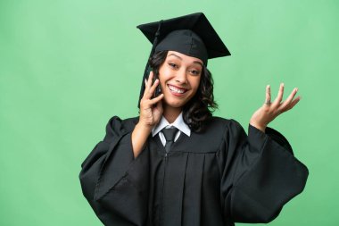 Üniversiteden mezun Arjantinli genç bir kadın cep telefonuyla sohbet ediyor.