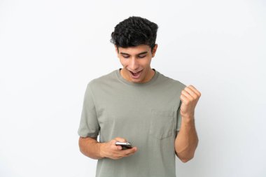 Beyaz arka planda izole edilmiş genç Arjantinli adam şaşırdı ve bir mesaj gönderiyor.