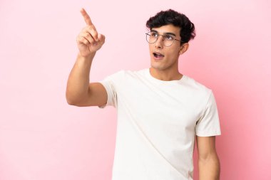 Pembe arka planda izole edilmiş genç Arjantinli adam...