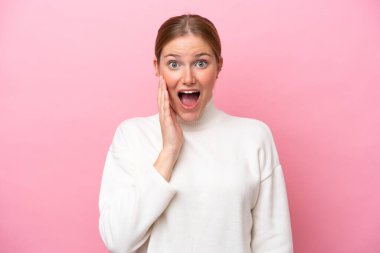 Pembe arka planda izole edilmiş beyaz bir kadın. Şaşırmış ve şok olmuş bir yüz ifadesi var.