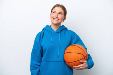 Beyazların arka planında basketbol oynayan beyaz bir kadın yukarı bakarken bir fikir düşünüyor.