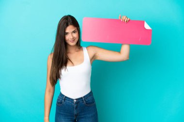 Genç Brezilyalı bir kadın mavi arka planda izole edilmiş, elinde boş bir pankart var.