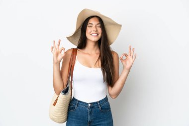 Pamela 'nın elinde plaj çantası olan Brezilyalı genç bir kadın zen pozuyla beyaz arka planda izole edilmiş.