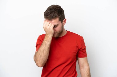 Beyaz arka planda başı ağrıyan genç beyaz bir adam.