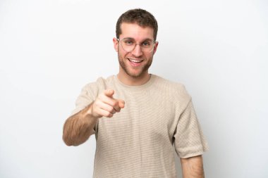 Beyaz arka planda izole edilmiş genç beyaz adam şaşırmış ve ön tarafı işaret ediyor.