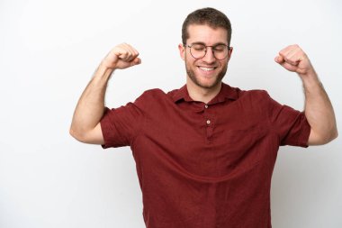 Beyaz arka planda izole genç beyaz adam güçlü jest yapıyor.