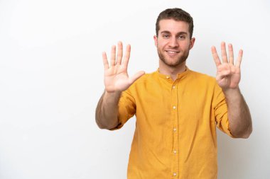 Beyaz arka planda izole edilmiş beyaz tenli genç dokuz parmaklı sayıyor.