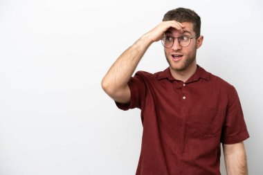 Beyaz arka planda izole edilmiş genç beyaz bir adam. Önüne bakarken sürpriz jest yapıyor.