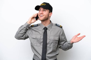 Beyaz arka planda izole edilmiş genç bir güvenlik görevlisi cep telefonuyla sohbet ediyor.
