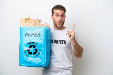 Beyaz arka planda izole edilmiş kağıdı geri dönüştürmek için elinde bir torba dolusu kağıt tutan beyaz bir adam çözümü fark ederken parmağını kaldırmayı amaçlıyor.