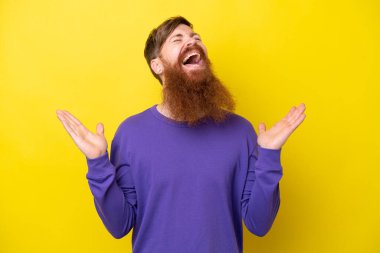 Sakallı kızıl saçlı adam, sarı arka planda izole edilmiş, gülümsüyor.