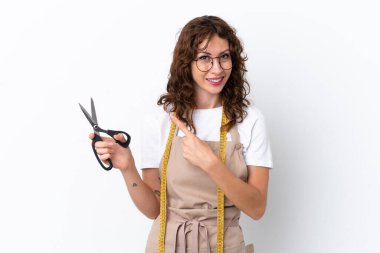 Beyaz arka planda izole edilmiş beyaz kadın beyaz bir ürünü sunmak için kenarı işaret ediyor.