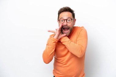 Beyaz arka planda izole edilmiş orta yaşlı beyaz bir adam bir ürün sunmak ve bir şeyler fısıldamak için kenarı işaret ediyor.