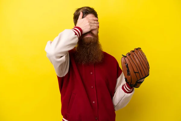 Redhead player man with beard with baseball glove isolated on yellow background covering eyes by hands. Do not want to see something