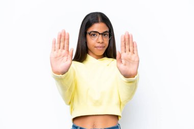 Beyaz arka planda izole edilmiş genç Afrikalı Amerikalı kadın dur hareketi yapıyor ve hayal kırıklığına uğruyor