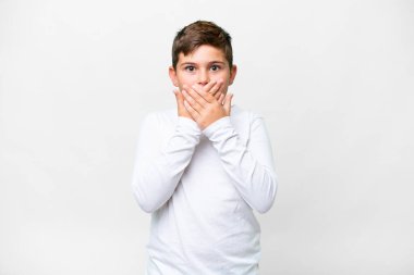 İzole edilmiş beyaz arka planda küçük beyaz çocuk elleriyle ağzını kapatıyor.