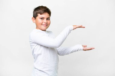 İzole edilmiş beyaz arka plan üzerinde küçük beyaz bir çocuk ilan vermek için kopyalama alanı tutuyor.