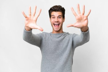 İzole edilmiş beyaz arka planda genç beyaz adam parmaklarıyla 10 'a kadar sayıyor.