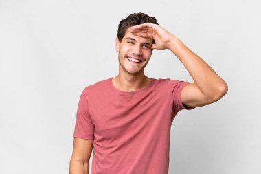 İzole edilmiş beyaz bir geçmişi olan yakışıklı beyaz bir adam bir şeye bakmak için uzaklara bakıyor.