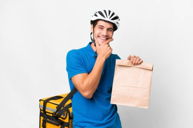 Kafkasyalı genç bir adam izole edilmiş arka plandan bir paket yemek alıyor. Mutlu ve gülümsüyor.