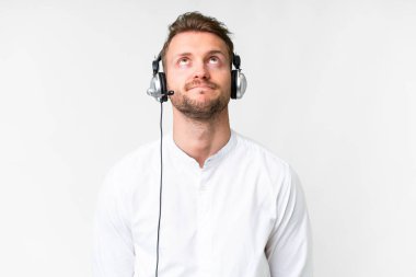 Tele pazarlamacı, beyaz bir arka planda kulaklıkla çalışan beyaz bir adam.