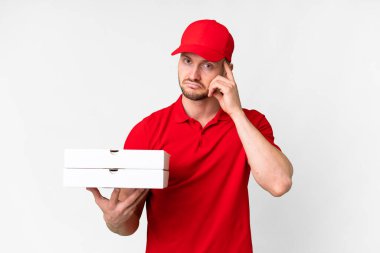 Pizza delivery man with work uniform picking up pizza boxes over isolated white background thinking an idea