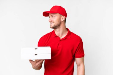 Pizza teslimatçısı üniformalı adam izole edilmiş beyaz arka planda pizza kutuları alıyor.