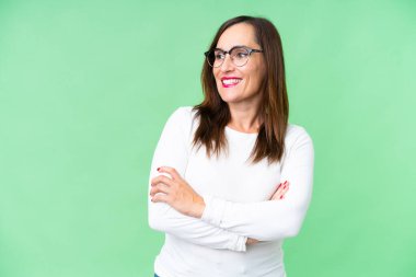 Orta yaşlı kadın izole edilmiş krom anahtar geçmişi mutlu ve gülümsüyor.