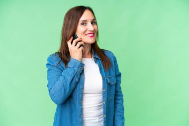 Renkli anahtar geçmişi olan orta yaşlı bir kadın cep telefonuyla sohbet ediyor.