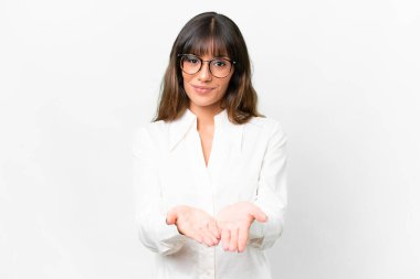 İzole edilmiş beyaz arka plan üzerinde genç beyaz bir kadın bir ilan vermek için avucunun içinde hayali bir mekan tutuyor.