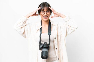 Genç fotoğrafçı, beyaz arka planda beyaz bir kadın, sürpriz bir ifadeyle.