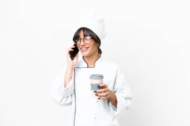 Kafkasyalı genç aşçı izole edilmiş beyaz arka planda kahve ve cep telefonu tutuyor.