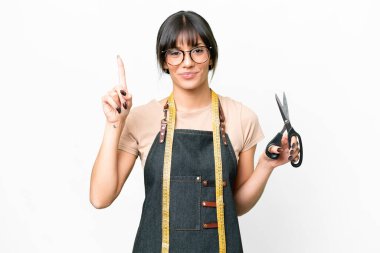 İzole edilmiş beyaz arka plan üzerinde genç beyaz terzi harika bir fikre işaret ediyor.