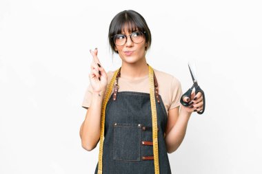 İzole edilmiş beyaz arka plan üzerinde genç beyaz terzi parmaklarını çapraz yapıp en iyisini diliyor.