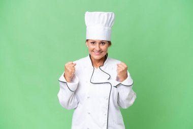 Orta yaşlı aşçı kadın, izole edilmiş arka planda zaferi kutluyor.