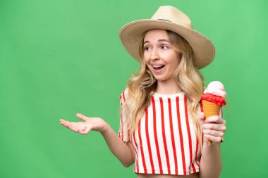 Kornet dondurması olan genç bir İngiliz kadın izole edilmiş bir arka plan ve şaşırtıcı bir yüz ifadesi var.