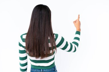 Beyaz arka planda izole edilmiş genç Afrikalı Amerikalı kadın işaret parmağıyla işaret ediyor.