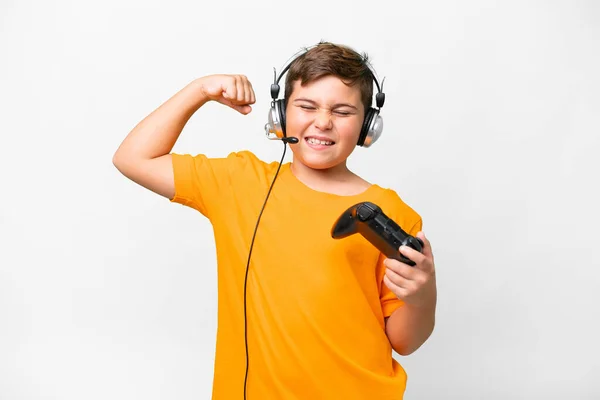 Stock image Little caucasian kid playing with a video game controller over isolated white background doing strong gesture